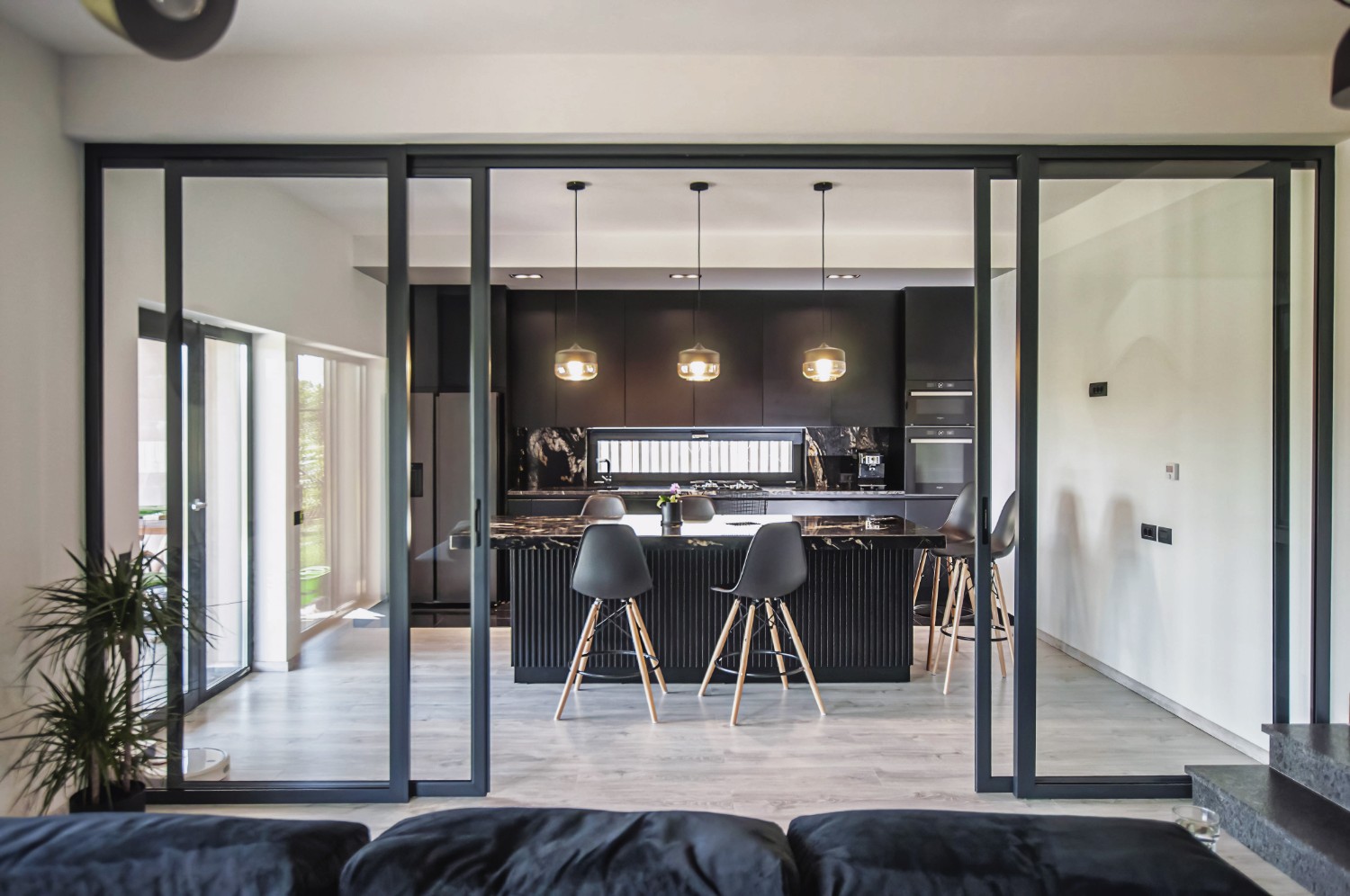 închidere bucătărie open space glasvand culoarea negru Amenajare casă Iași - decor negru modern - living separat de bucătărie cu uși de sticlă cu cadru metalic