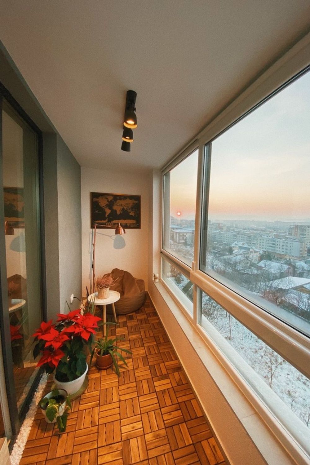 balcon de apartament la bloc inchis cu termopane si amenajat ca zona de relaxare, cu parchet si fotoliu