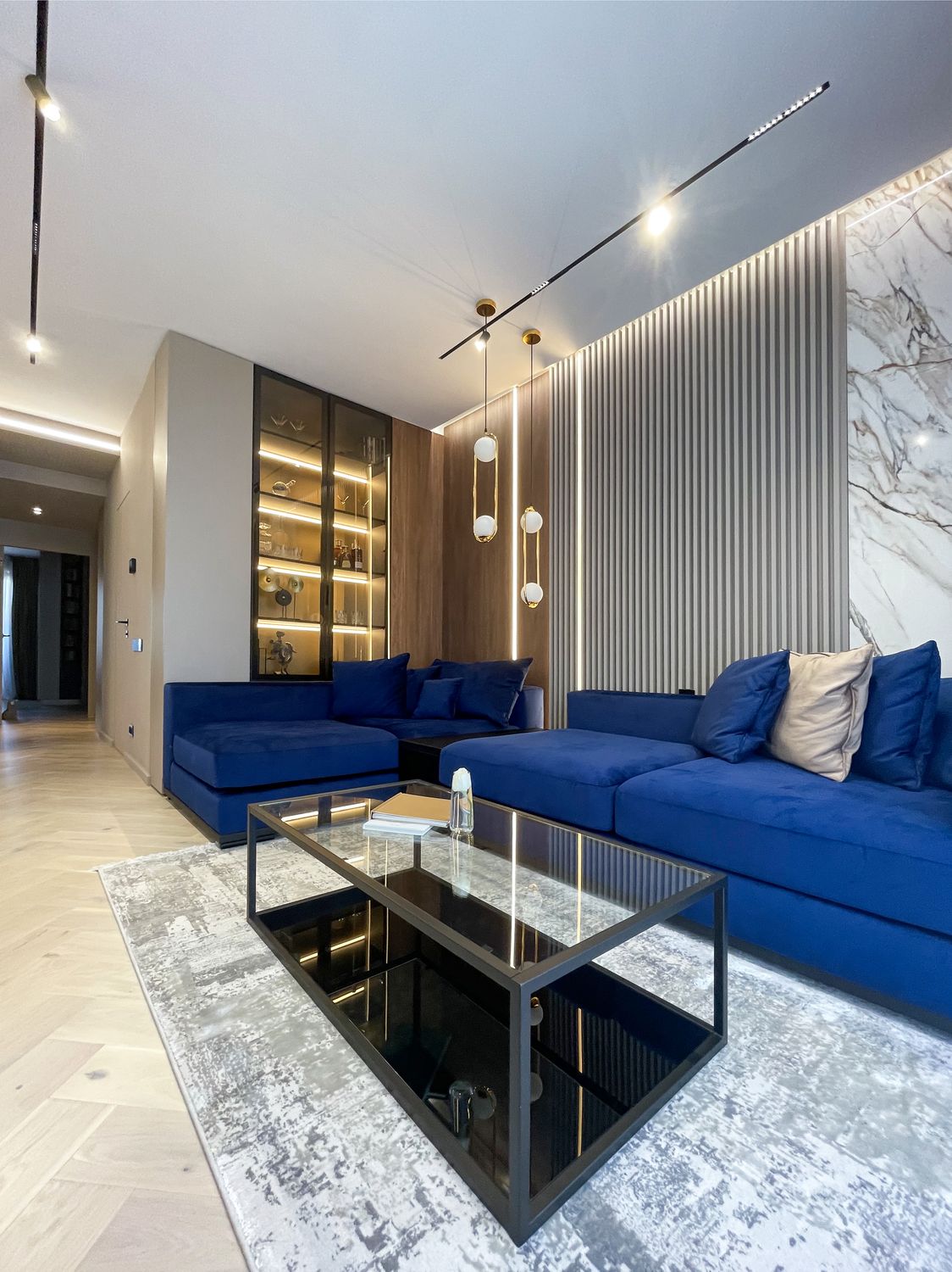 amenajare stil modern living combinatie de culori pentru albastru si gri canapea albastra covor gri pereti marmura riflaje gri lumini led