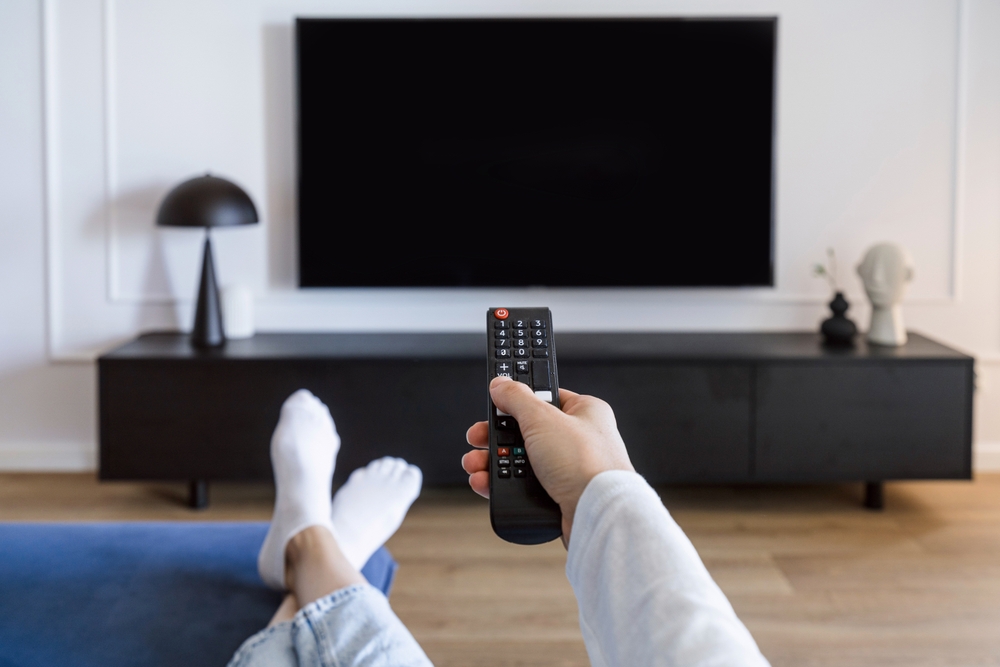 televizor în living femeie cu telecomanda 
