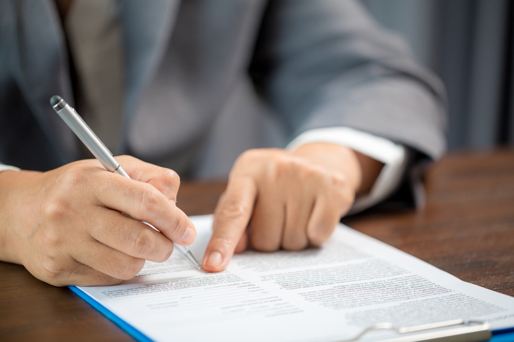 semnare contract de închiriere de către barbat care citește documentul