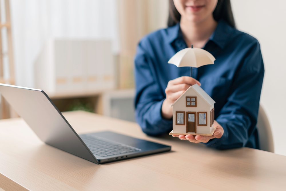 verificare poliță de asigurare locuinta de către femeie pe laptop